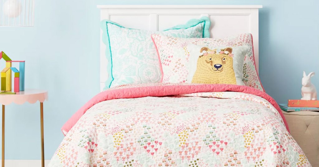 pink printed quilt on a kids bed