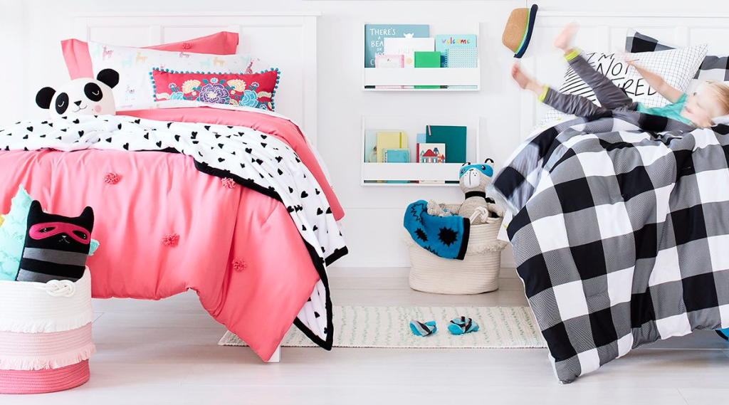 kid jumping on a bed in a bedroom with two beds