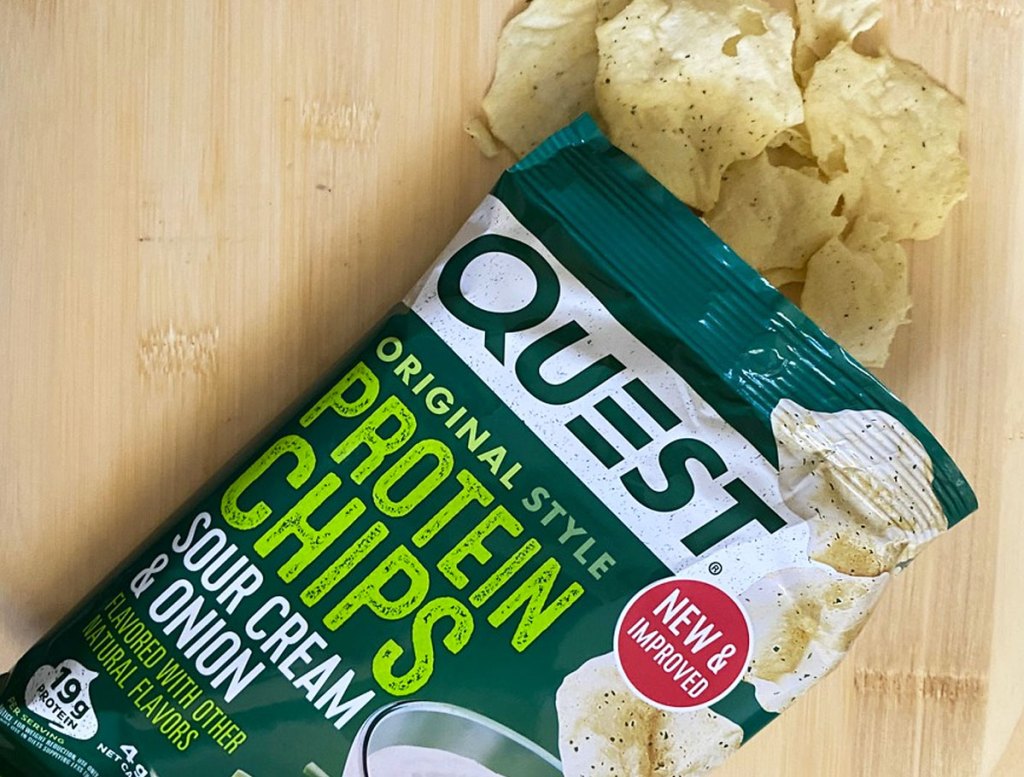 green bag of quest sour cream & onion chips with chips spilling out of the bag