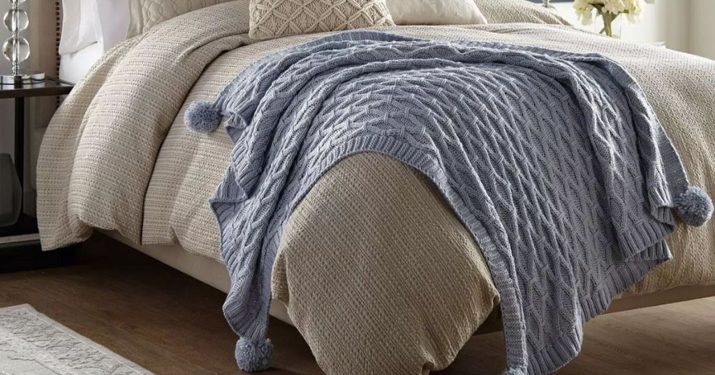 Sam's Club Created by Catherine Pom Pom Knit Throw Blanket draped on a bed
