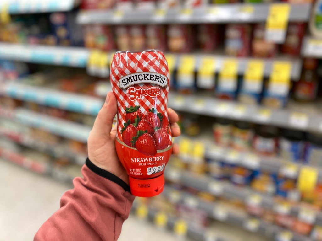 man's Hand holding Smuckers Squeeze Jelly