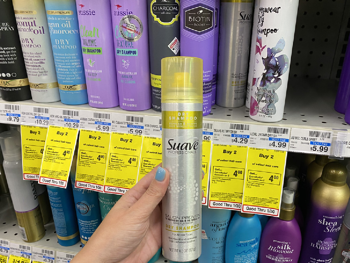 woman's hand holding dry shampoo in store