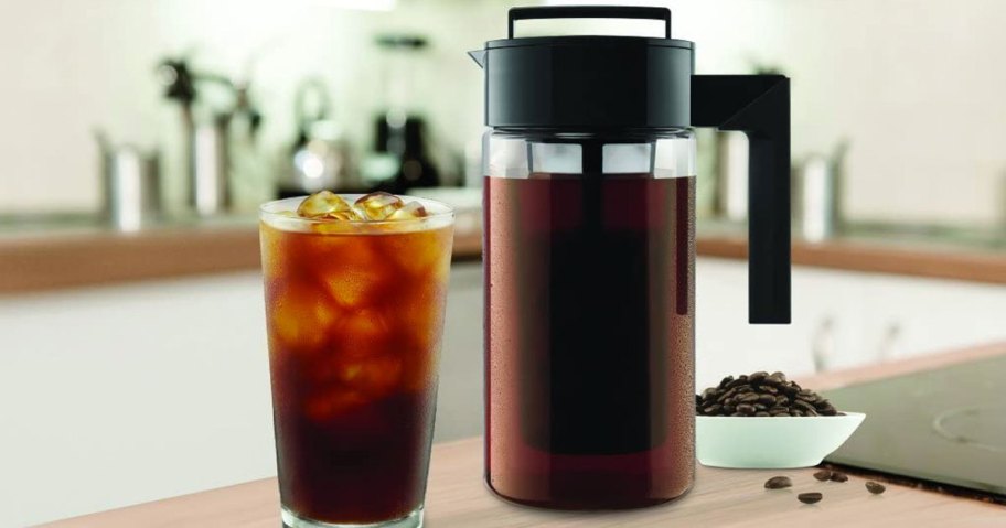 cold brew coffee pitcher on kitchen counter next to glass filled with coffee