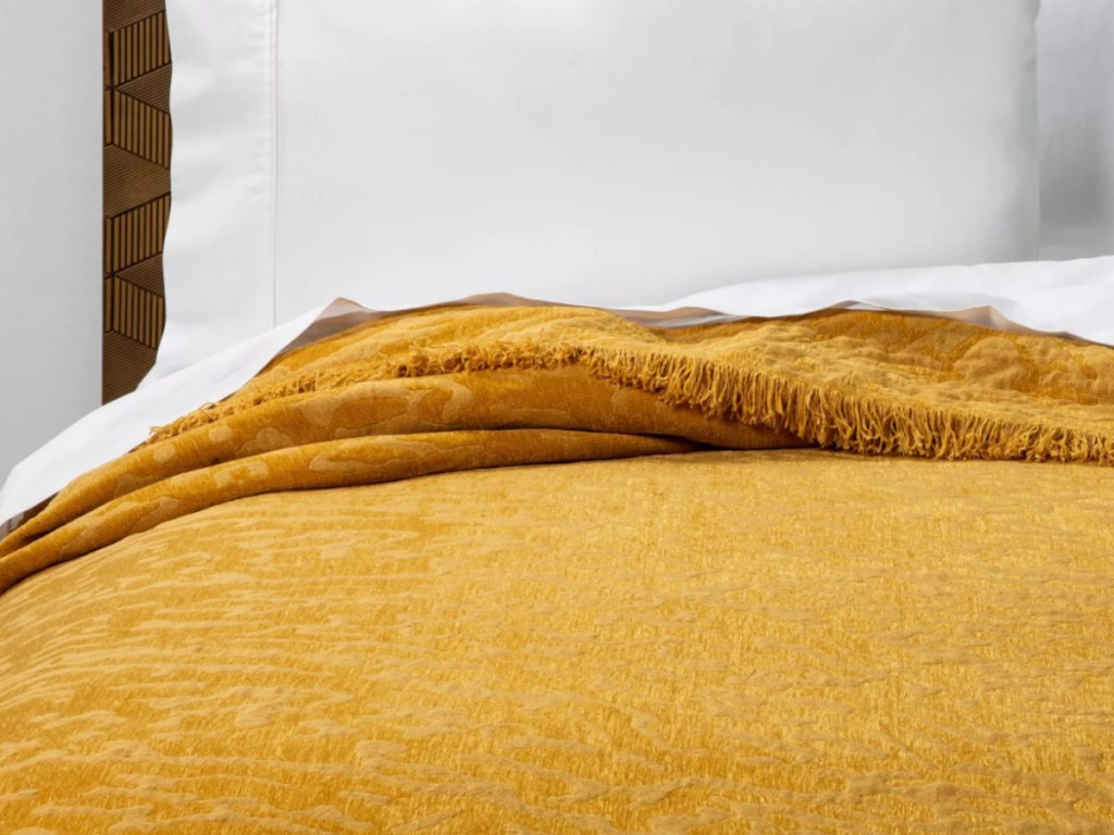 target chenille saffron colored blanket on a bed