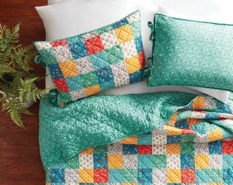 patchwork pillows and quilt on a bed