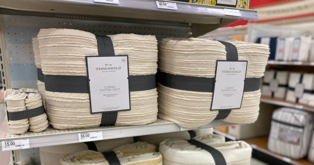 two beige textured quilts on shelf 