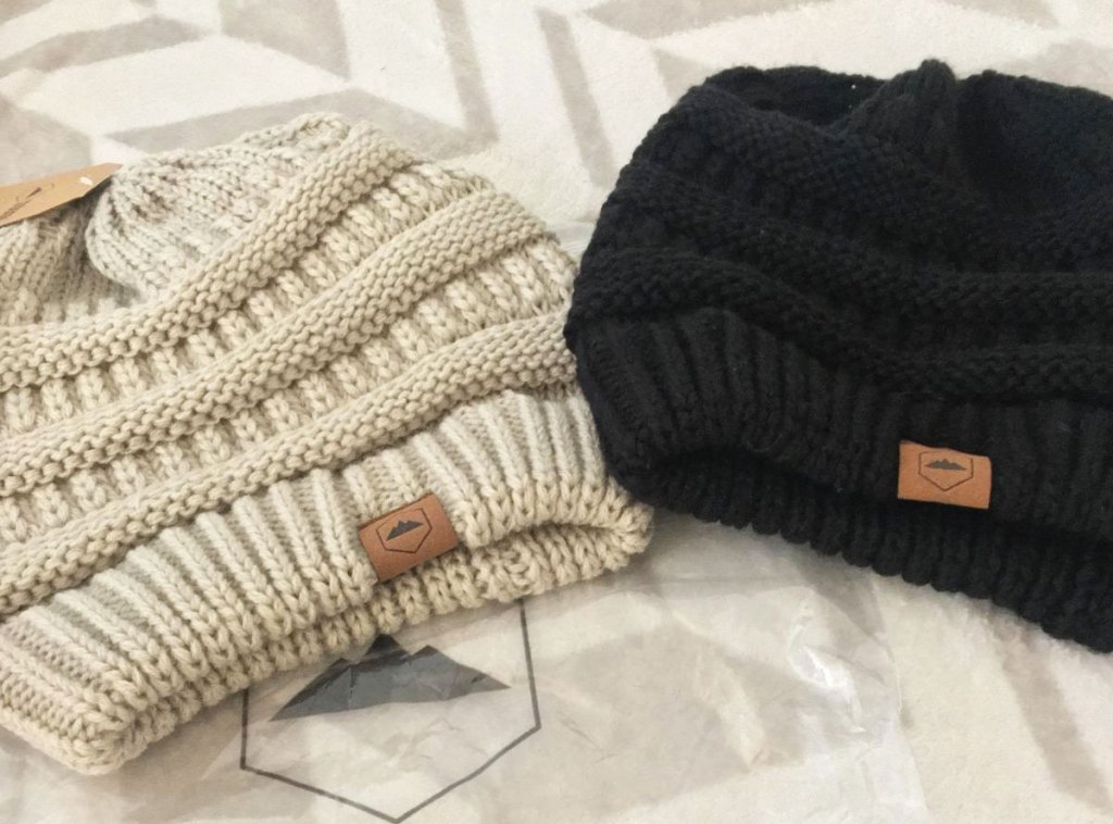 two cable knit beanies in cream and black colors