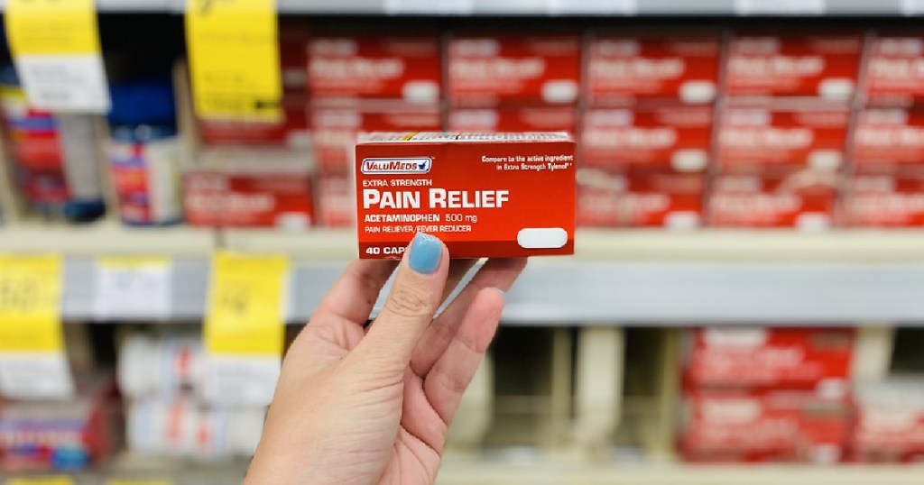 woman's hand holding box of pain relief caplets