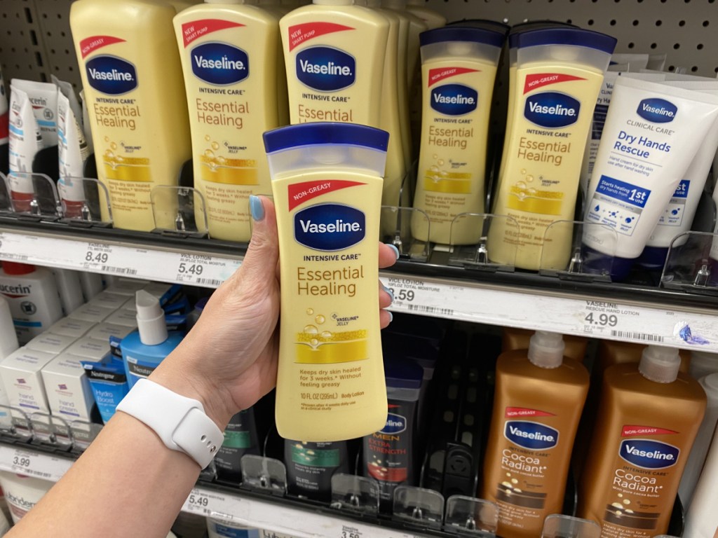 woman' hand holding bottle of lotion in store