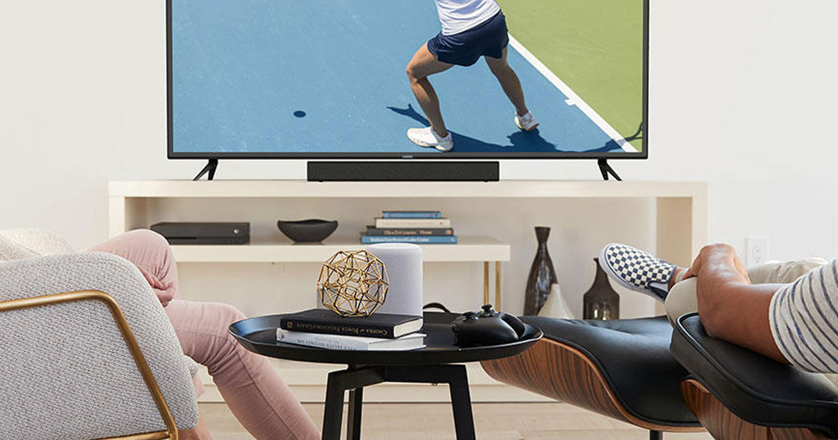 people watching tv with a black soundbar on tv stand