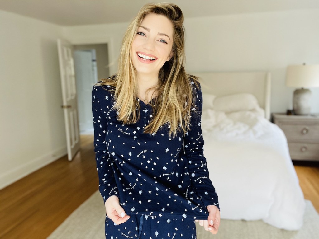 woman laughing wearing navy blue pajamas