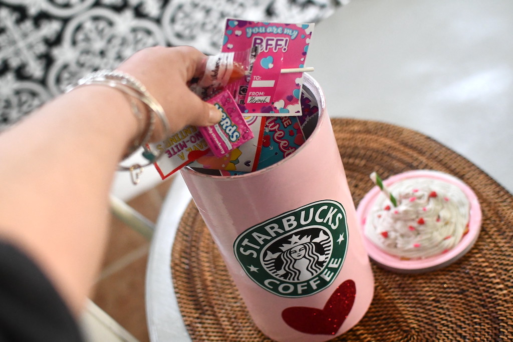 filling Starbucks DIY Valentine's container with candy 