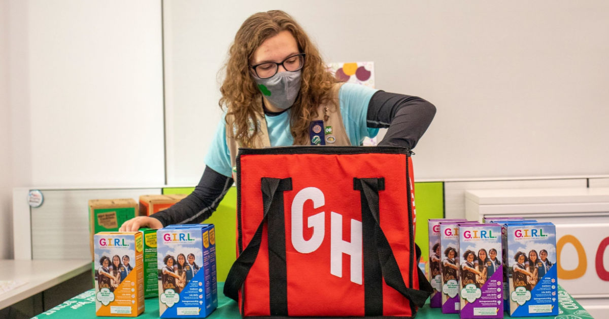 Girl Scout putting cookies in GrubHub bag