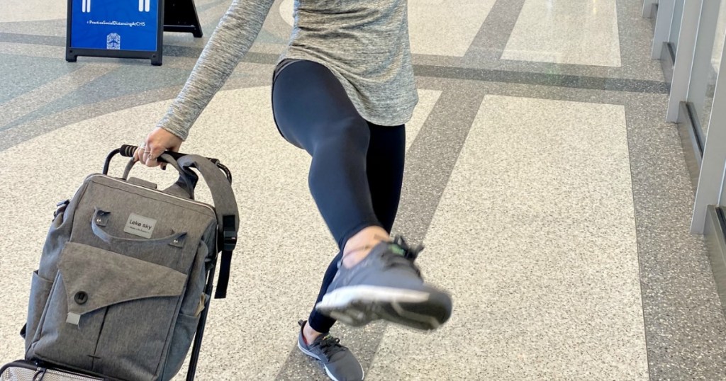 woman in airport kicking up leg wearing black lululemon leggings dupes