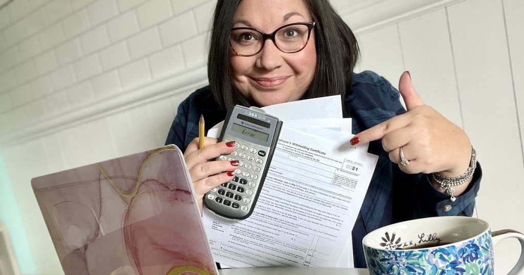 woman holding calculator and tax forms