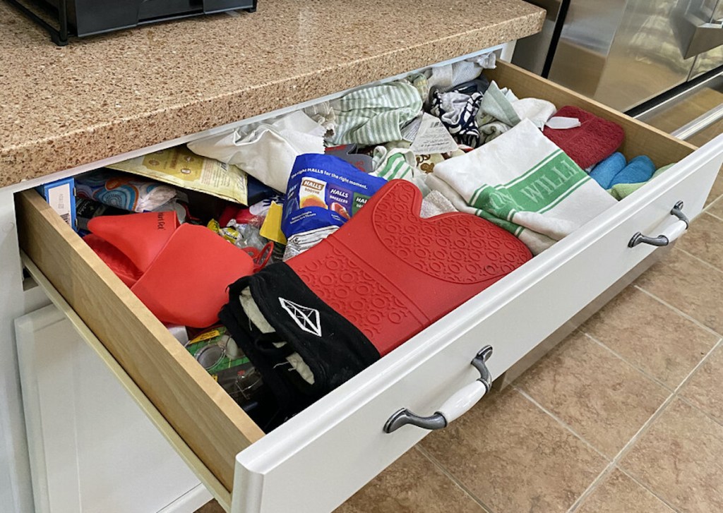 tons of clutter and junk in messy kitchen drawer