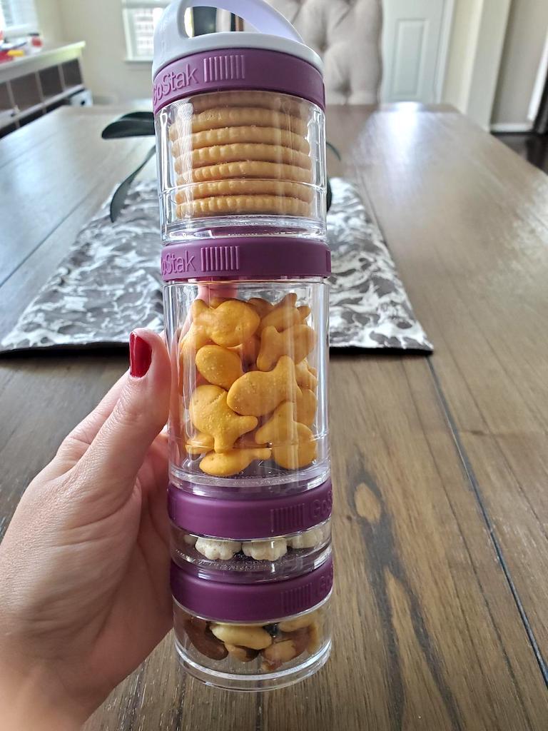 holding stacked containers filled with snacks