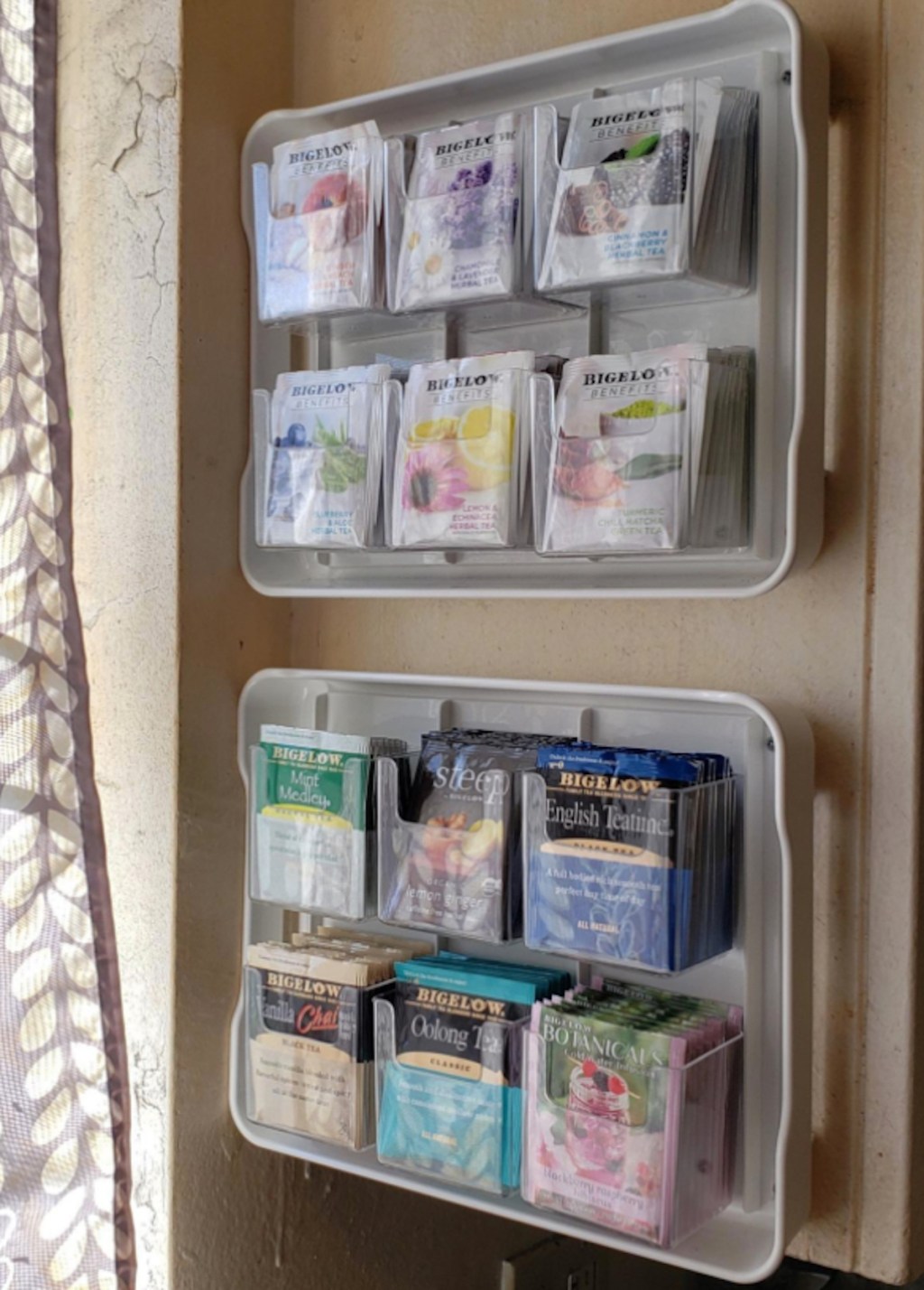 two tea organizers hanging on wall with tons of various tea bags