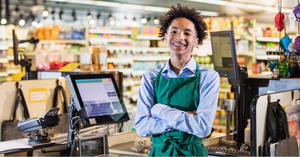 teen standing at cash register