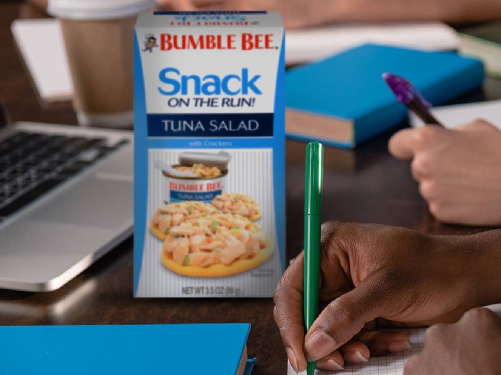 tuna and crackers kit box on desk with students taking notes by laptop