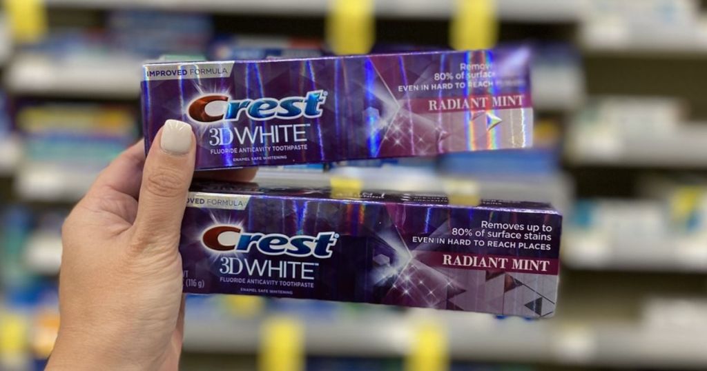 hand holding 2 Crest 3D White Toothpastes