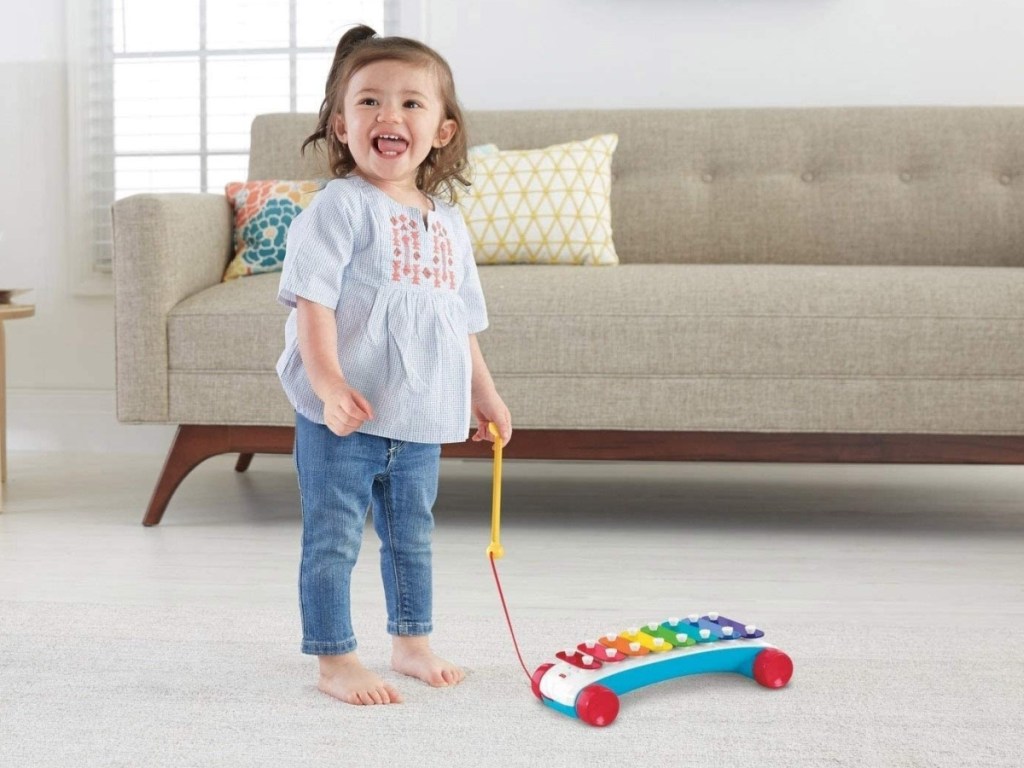little girl playing with a Fisher-Price Classic Xylophone