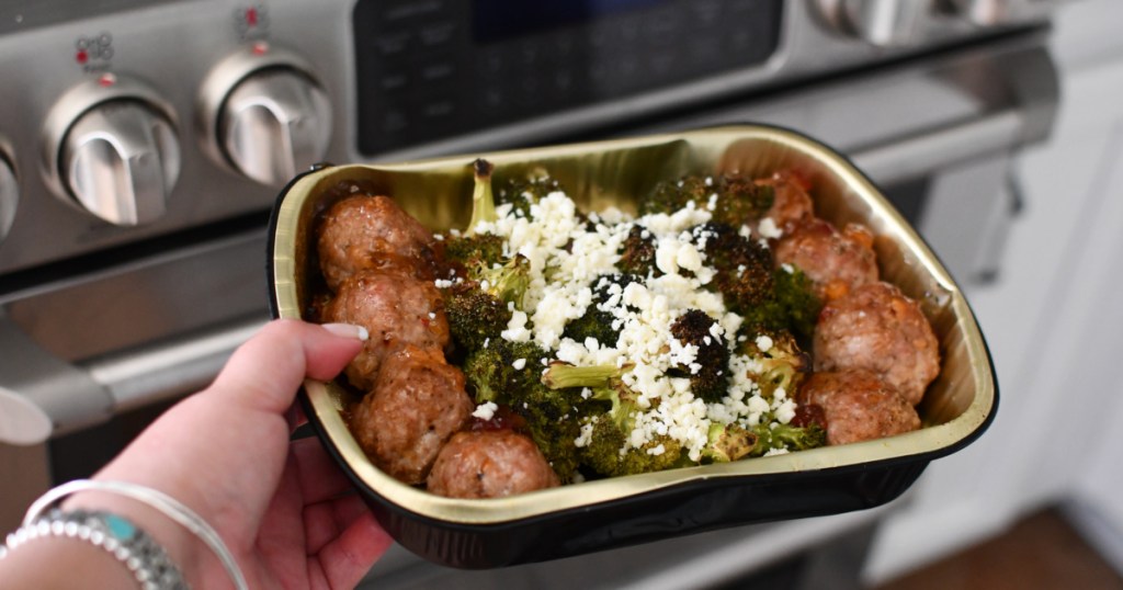 hand holding home chef meal in oven pan with meatballs, broccoli and cheese