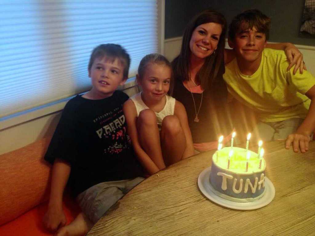 woman with three kids and birthday cake