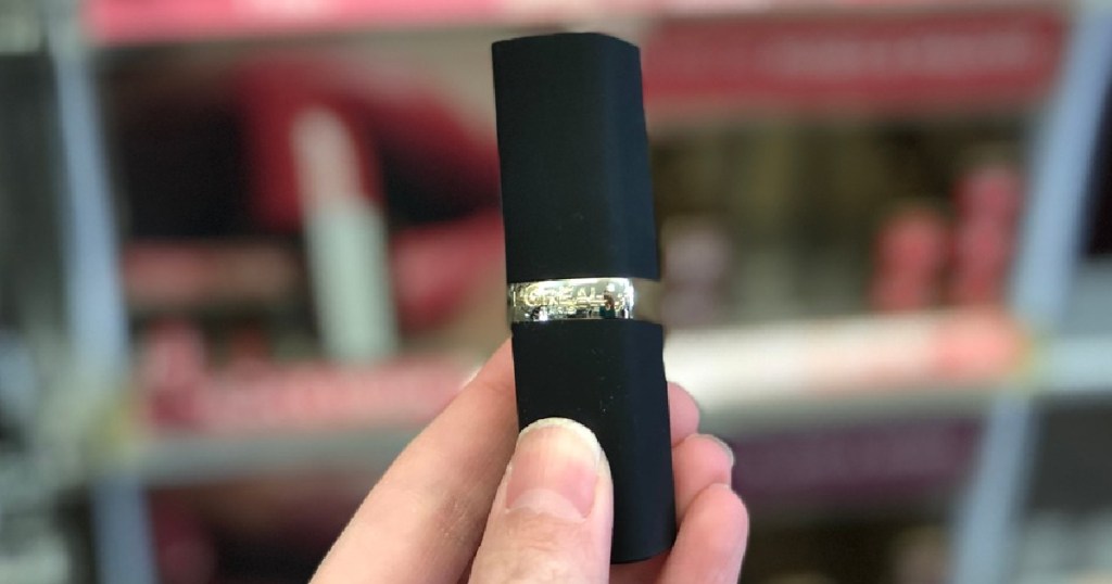 hand holding tube of lipstick in store