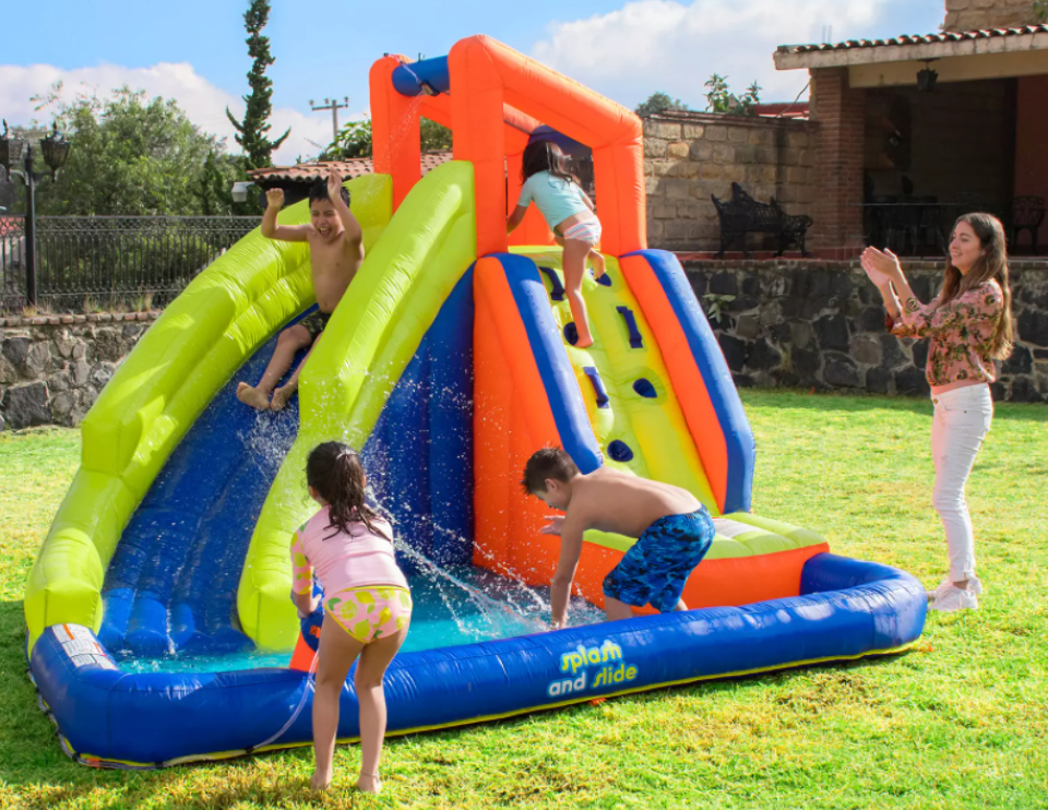 kids playing on an inflatable waterslide