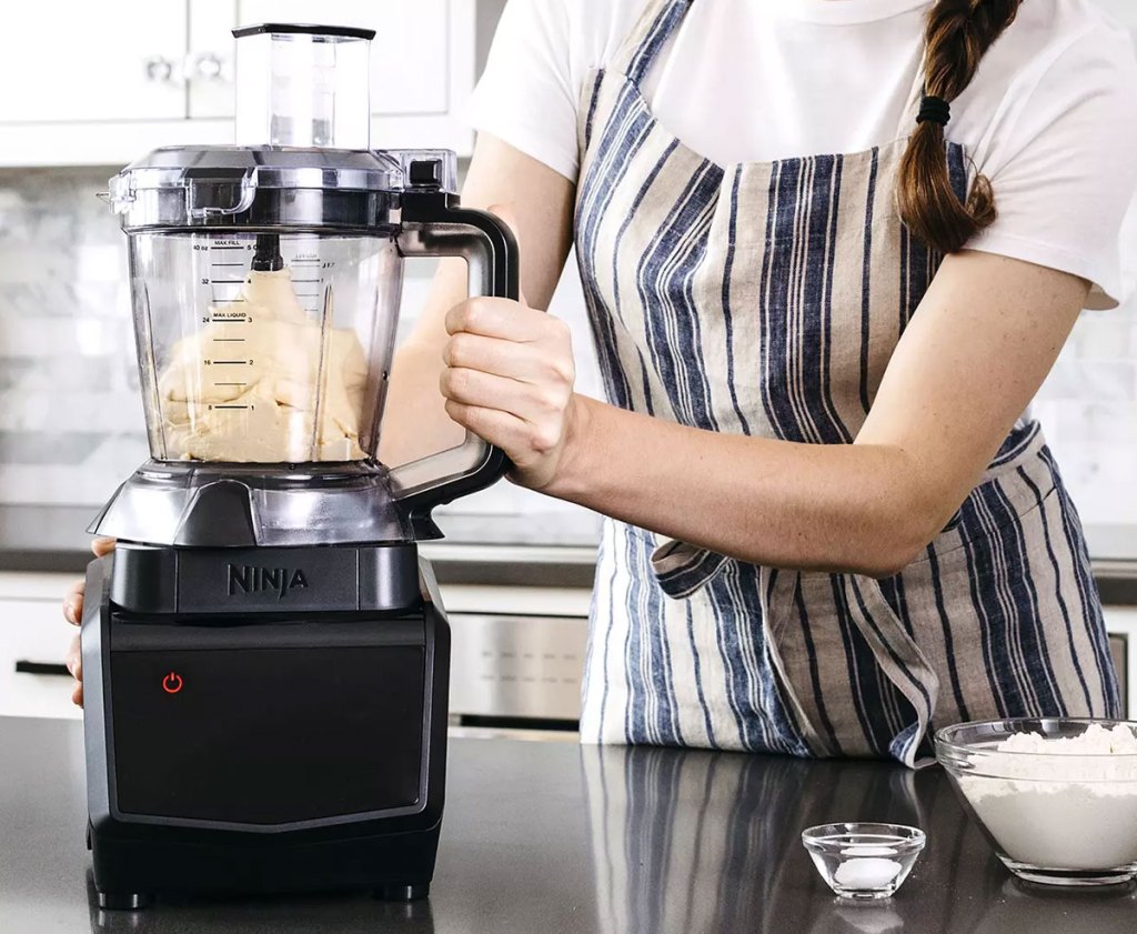 woman mixing dough in ninja blender with food processor attachment