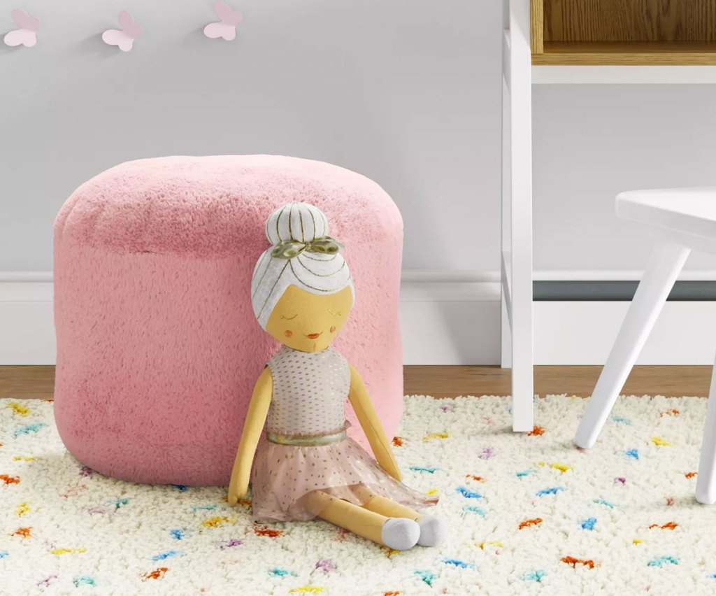 pink kids pouf with a doll leaning against it