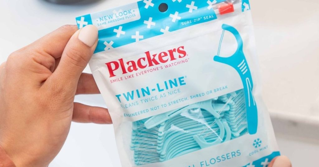hand holding a pack of Plackers Twin Line Flossers
