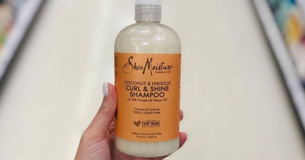 hand holding a bottle of SheaMoisture shampoo