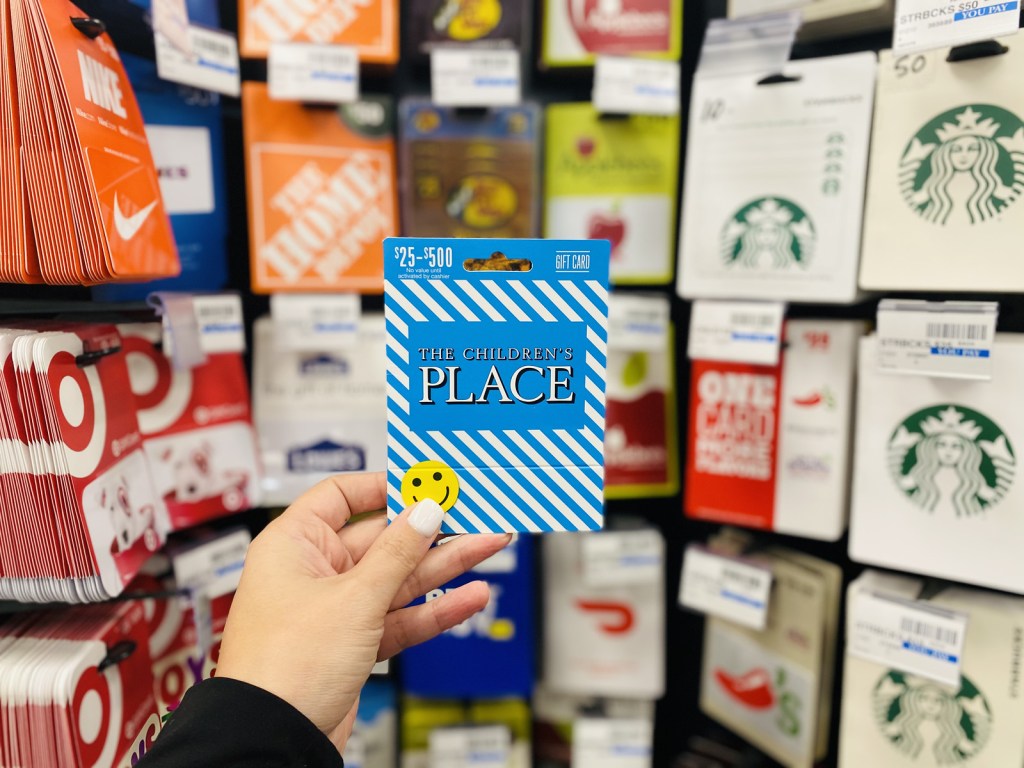 woman holding up The Children's Place Gift Card