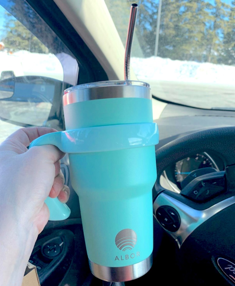 hand holding a blue travel coffee mug