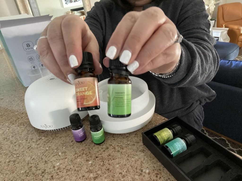 woman holding two essential oils