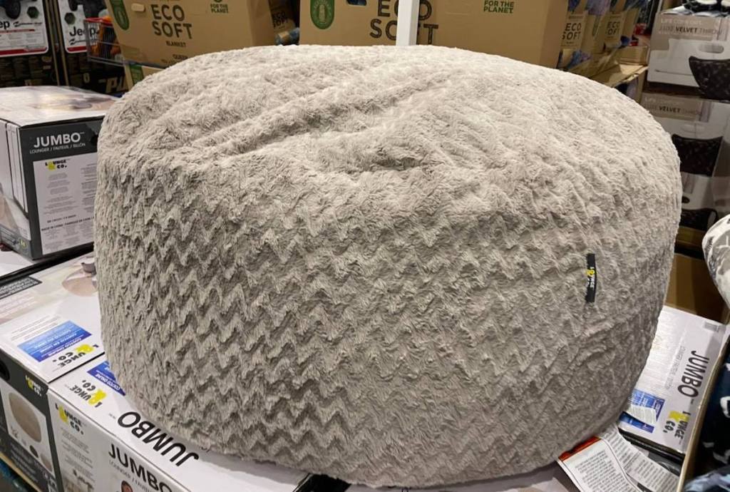 beige fur bean bag chair sitting on boxes in club store