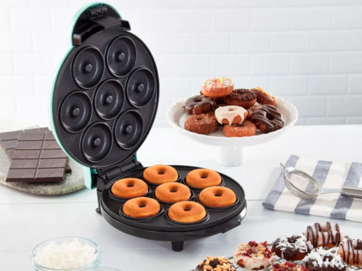 donut maker on counter with various decorated treats