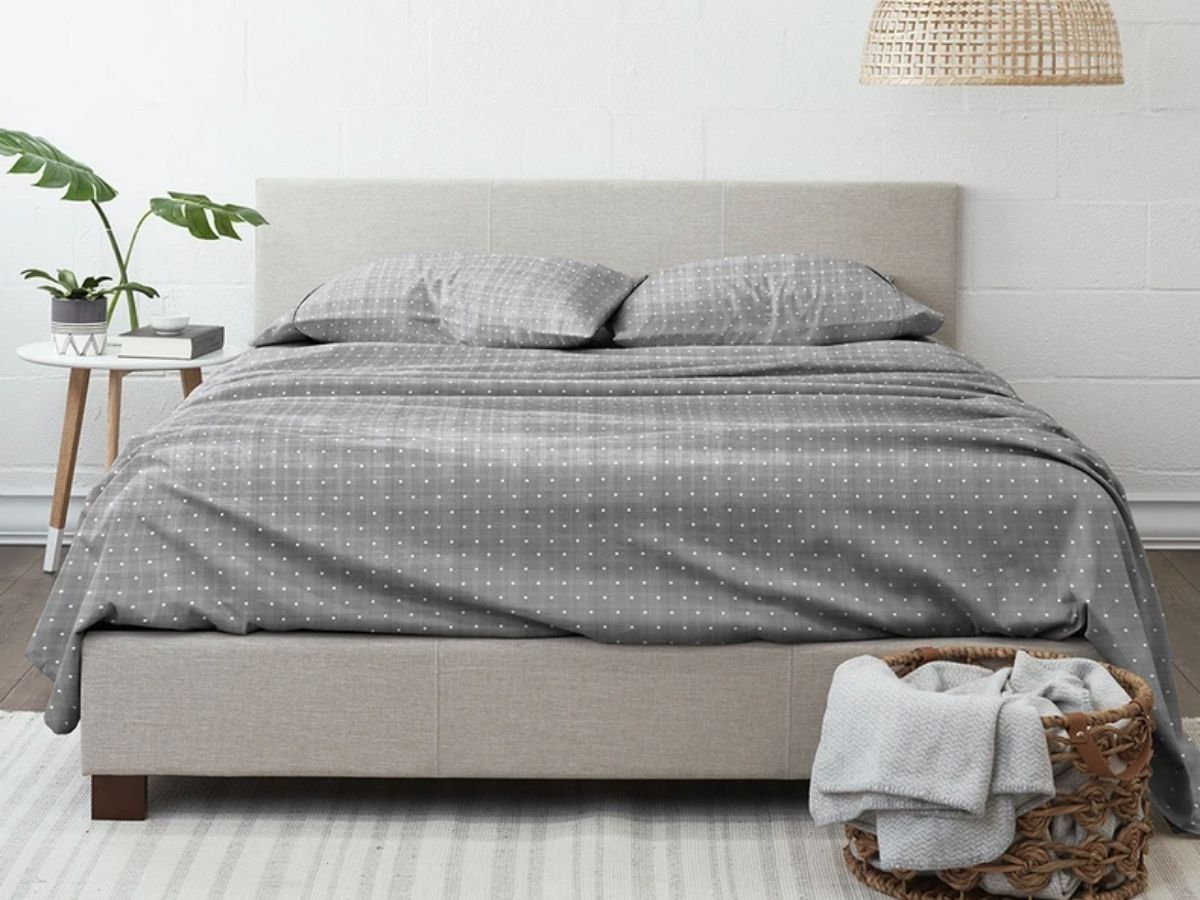 gray and white polka dot sheets on bed