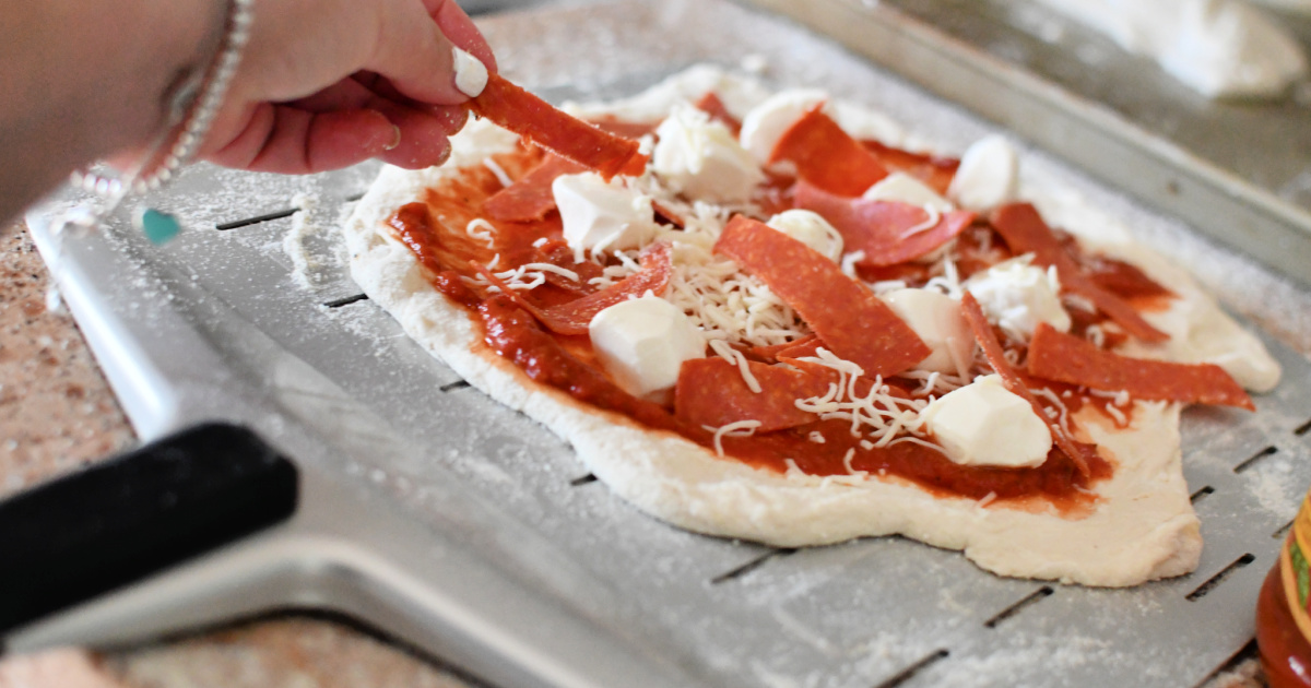 Making pizza on an pizza peel for a low effor meal idea.
