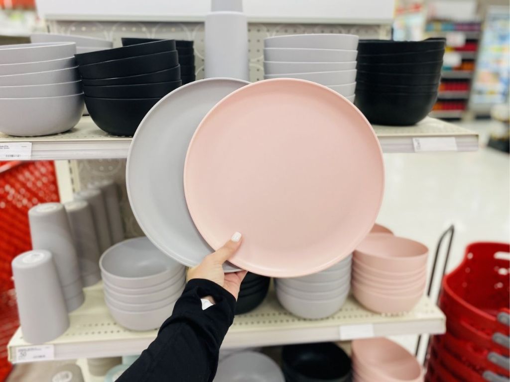 hand holding pink and gray plastic plates
