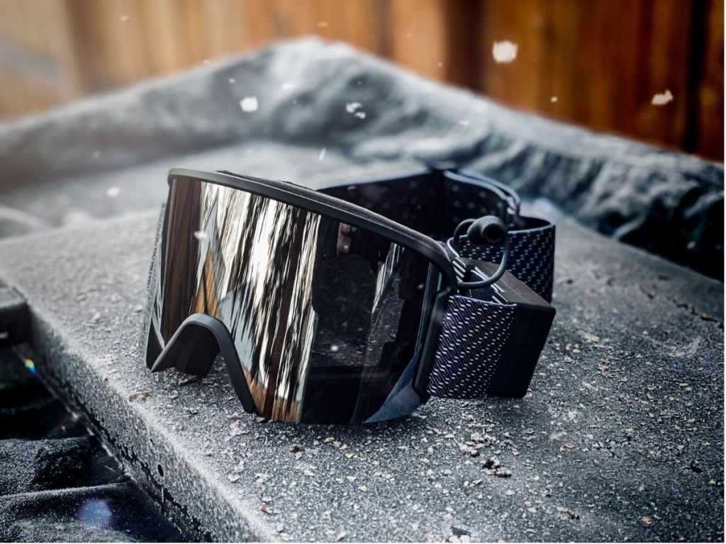 Ski goggles sitting on black surface