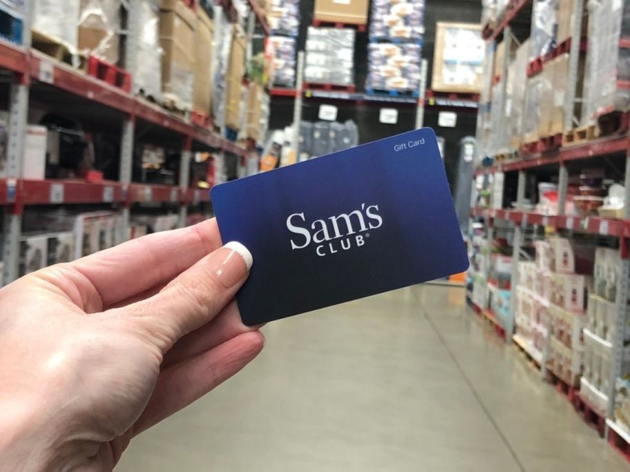 person holding up blue sam's club gift card
