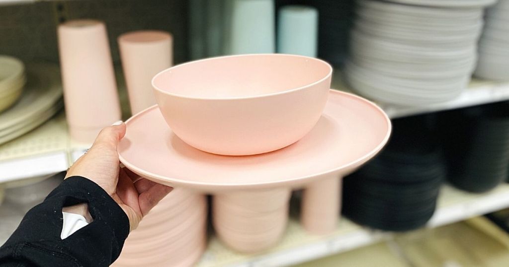 hand holding pink plastic bowl and plate