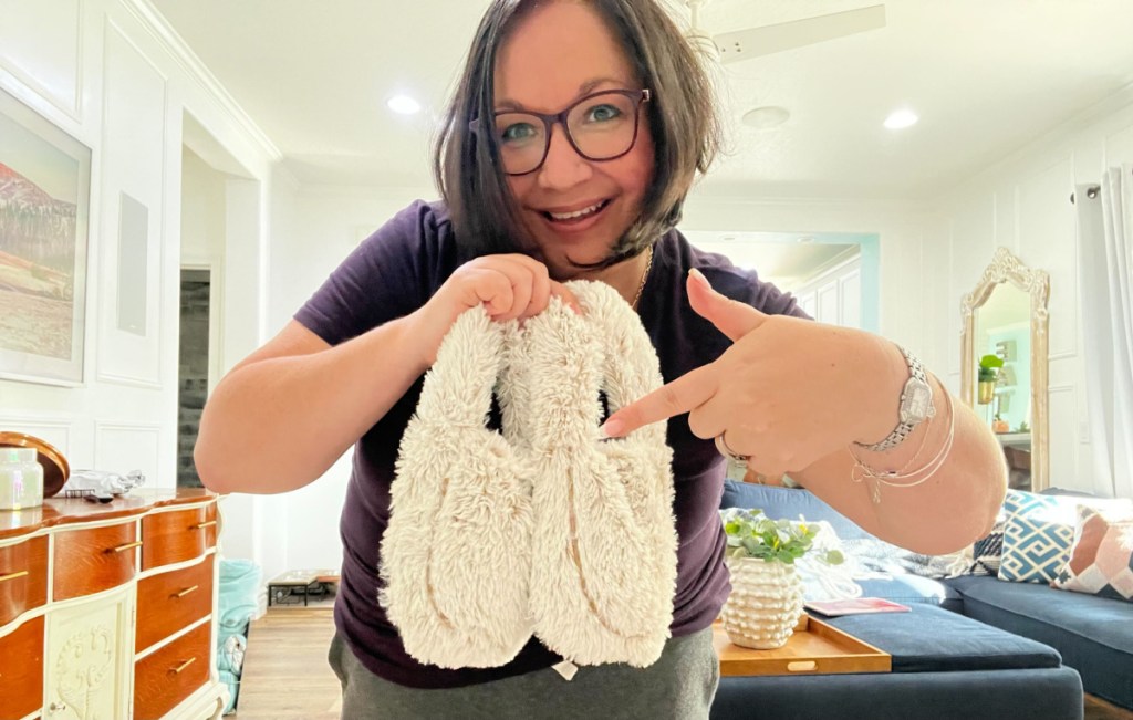 woman pointing to a pair of warmies slippers
