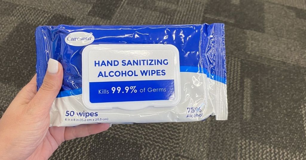 hand holding a package of alcohol wipes
