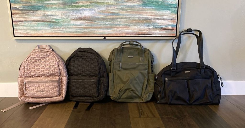 rose gold quilted backpack, black quilted backpack, green soho bag and black weekend bags lined up against wall with painting