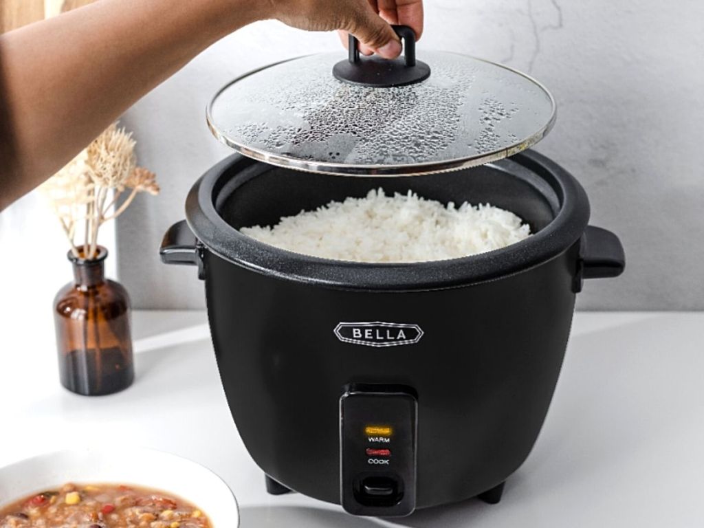 hand taking top off of Bella rice maker