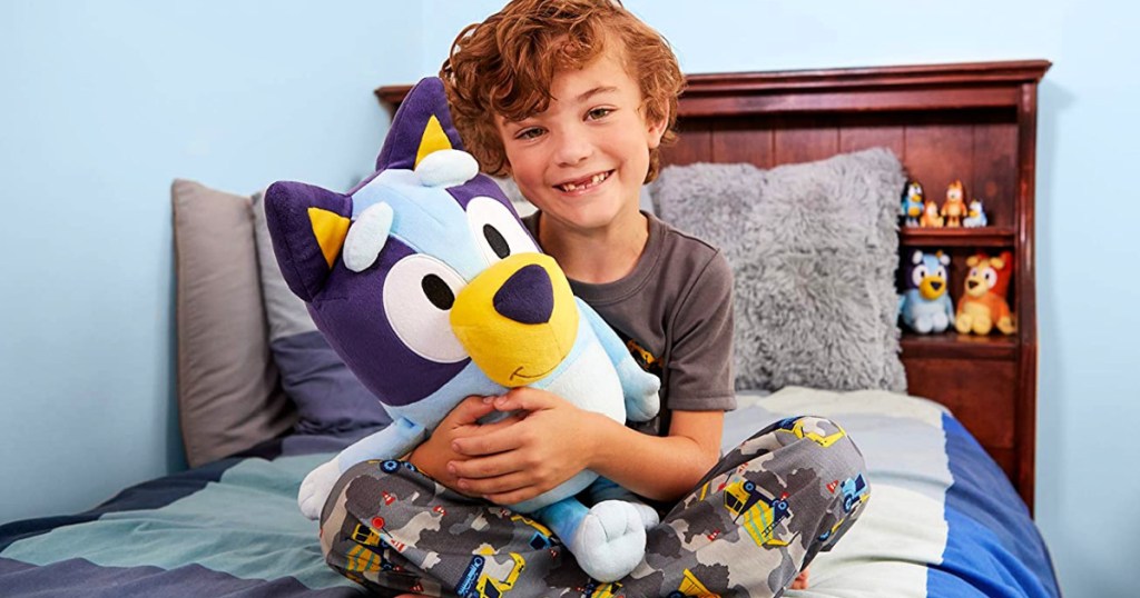 boy holding a Bluey Best Mate Jumbo Plush